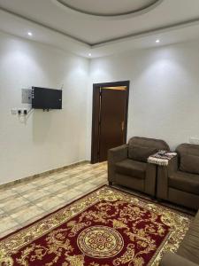 a living room with a couch and a flat screen tv at جوهرة عسير in Abha