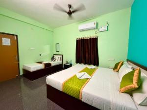 a bedroom with two beds with green walls at De Quite Villa in Pondicherry