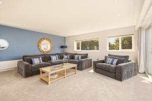 a living room with two couches and a table at Beadnell Point - North East Escapes in Beadnell