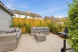 a patio with wicker furniture and a wooden fence at Beadnell Point - North East Escapes in Beadnell +54 photos