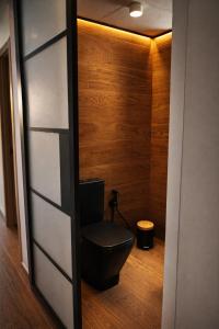 a toilet in a room with a wooden wall at Frente al mar , Piscina ,Playa in El Campello +6 photos