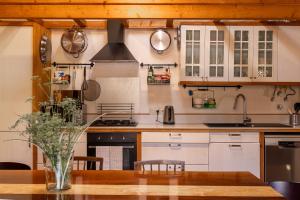 a kitchen with white cabinets and a wooden table at Monte D´Sancho in Aljezur