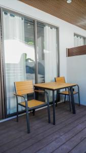 two benches and tables in a room with windows at Lagoon Dhigurah in Dhigurah
