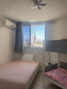 a small bedroom with two beds and a window at 123Eilat panorama in Eilat