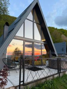 a house with a large group of glass windows at Klek 77 Luxury Chalets near Jahorina in Paočići
