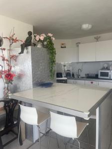a kitchen with a large white counter and white chairs at 123Eilat panorama in Eilat