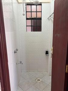 a bathroom with a shower with a window at Prestige apartments Machakos in Machakos +20 photos