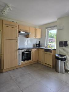 a large kitchen with wooden cabinets and a window at De Mossel 147 in Bruinisse