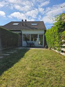 a house with a patio and a table at De Mossel 147 in Bruinisse