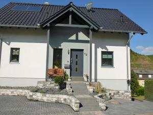 a white house with a black roof at Pension Susanne in Bruttig-Fankel