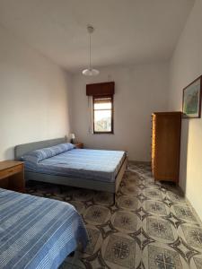 a bedroom with two beds and a window at Terrazza delle Acacie in Villaggio San Leonardo