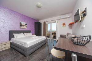 a bedroom with a bed and a purple wall at Alessandra Apartments & free private parking in Sveti Stefan