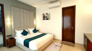 a bedroom with a bed with blue and white pillows at Radiance Hotel in Sirsa +27 photos