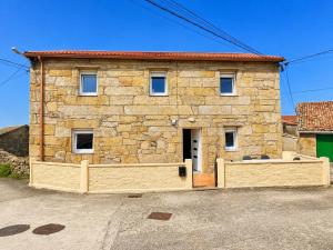 a stone house with a gate in front of it at Casa Panches, con Vistas al Mar in Panchés