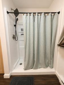a shower curtain in the corner of a bathroom at Clocked Out Cabin with Lake Access, Fire Pit, Games in Blakeslee +28 photos