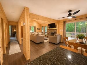 a living room with a couch and a table at Clocked Out Cabin with Lake Access, Fire Pit, Games in Blakeslee
