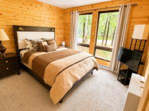 a bedroom with a bed and a large window at Clocked Out Cabin with Lake Access, Fire Pit, Games in Blakeslee
