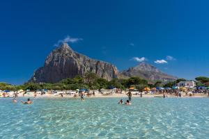 a group of people in the water on a beach at Casa Isulidda in San Vito lo Capo