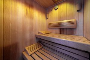 a sauna with wooden walls and wooden shelves in it at Hotel Schöpf - Mountain Hideaway in Längenfeld
