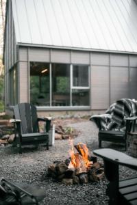 a fire pit in front of a house with two chairs at The Cape in Rawdon