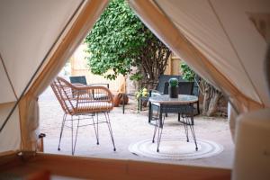 a tent with a table and chairs in a yard at Glamping Rivera del Mar - RV Park in Loreto