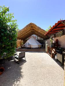 a tent and a table and a bench in a yard at Glamping Rivera del Mar - RV Park in Loreto