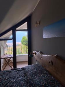 a bedroom with a bed and a large window at Fuga dalla città in Aidone