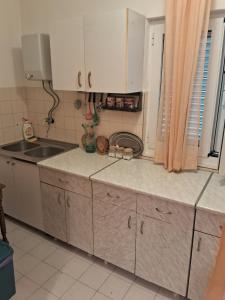 a kitchen with white cabinets and a sink at Bosiljak in Zelenika +1 photo