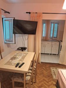 a dining room table with a television on top of it at Bosiljak in Zelenika