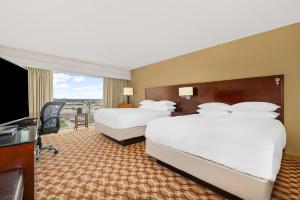 a hotel room with two beds and a flat screen tv at Louisville Marriott East in Louisville