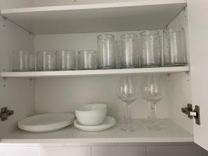 a shelf filled with glasses and plates and bowls at Cozy 1 Br Apt with TV, Workstation, Kitchenette & Parking in Mississauga