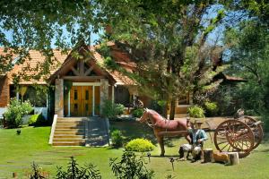 a house with a horse statue in front of it at Posada de Campo - Hotel Boutique - Adults Only in Villa General Belgrano