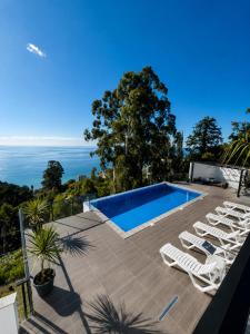 a villa with a swimming pool and the ocean at Villa Deluxe Kvariati in Kvariati