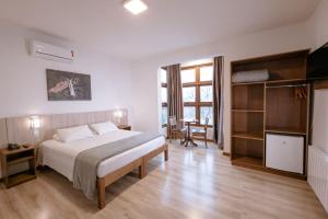 a hotel room with a bed and a television at Hotel Triveneto Gramado in Gramado