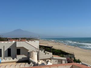 a view of a beach with a building and the ocean at Terrazza delle Acacie in Villaggio San Leonardo