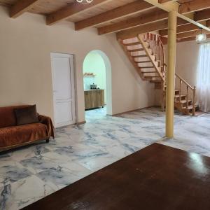 a living room with a staircase and a couch at Сабудара in Martvili +1 photo