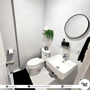 a bathroom with a toilet and a sink and a mirror at Blanc Suite in Roxas City