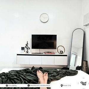 a person laying on a bed with their feet on the bed at Blanc Suite in Roxas City