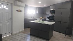 a kitchen with gray cabinets and a white counter top at Casa Alentejana in Mora