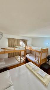 a room with three bunk beds and a desk at Hostal Beko in Cali