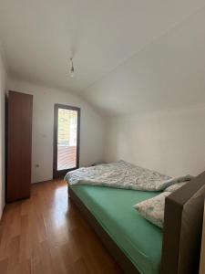 a bedroom with a green bed in a room at Mate Apartmani in Bijelo Polje