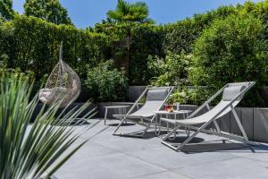 two lounge chairs and a table in a garden at Landidyll Hotel Restaurant Weidenbrück & SPA in Swisttal