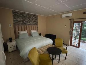 a bedroom with a bed and a table and chairs at Mafofolozi Lodge in Hartbeespoort +27 photos