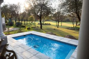 a swimming pool with a view of a yard at Le Vaal Manor in Parys