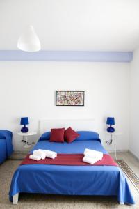 Schlafzimmer mit einem blauen Bett und roten Kissen in der Unterkunft B&B Alchimia Napoletana in Neapel