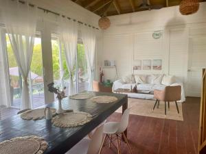 a living room with a couch and a table and chairs at HOLBOX PUERTA DEL MAR in Holbox Island
