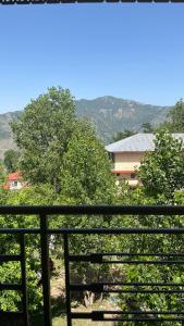 a balcony with a view of trees and a building at Sunset Lodges Bhurban in Bhurban