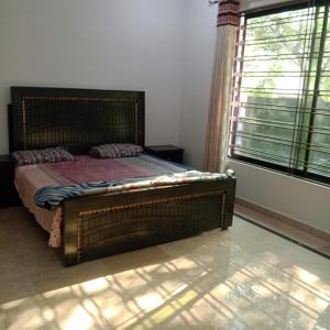 a bedroom with a wooden bed with a window at Sunset Lodges Bhurban in Bhurban