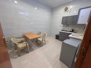 a kitchen with a table and chairs and a sink at سرور للشقق المخدومة in Al Baha