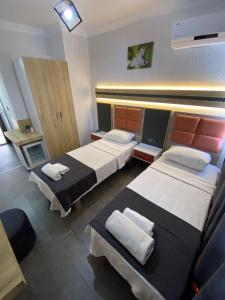 a hotel room with two beds with towels on them at KENT HOTEL Didim in Didim